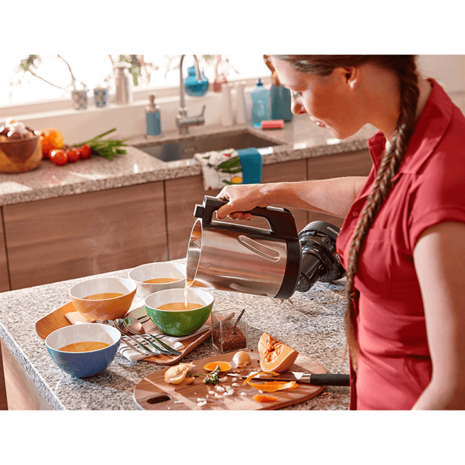 Máquina para Sopas Philips HR2203 Cremas y Compotas 1.2L sirviendo crema de sopa en cuencos coloridos.
