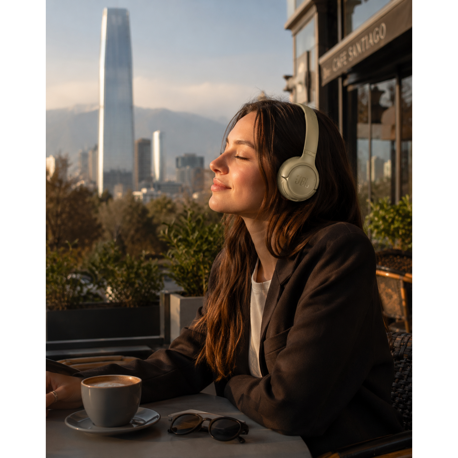 Mujer disfrutando de la música con audífonos bluetooth JBL Tune 530BT en un café al aire libre.